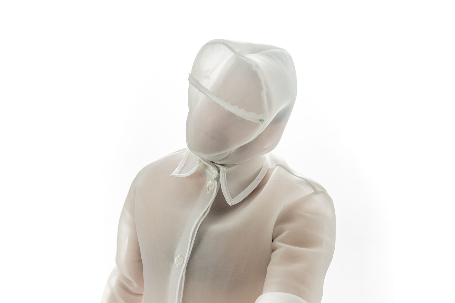 Translucent, faceless mannequin wearing a white, hooded outfit with a collared shirt, against a plain background.